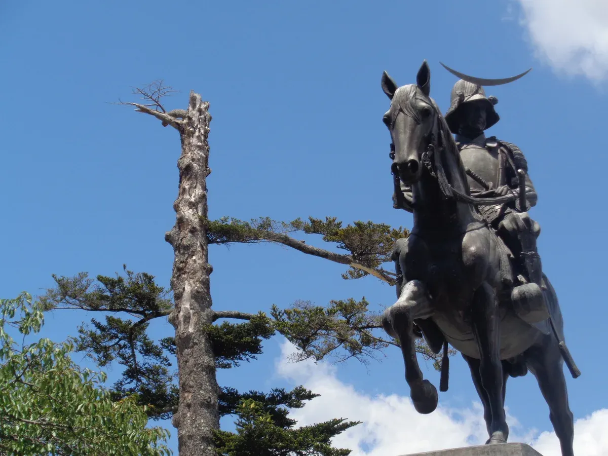 Bronze statue of Date Masamune on horseback against a blue sky