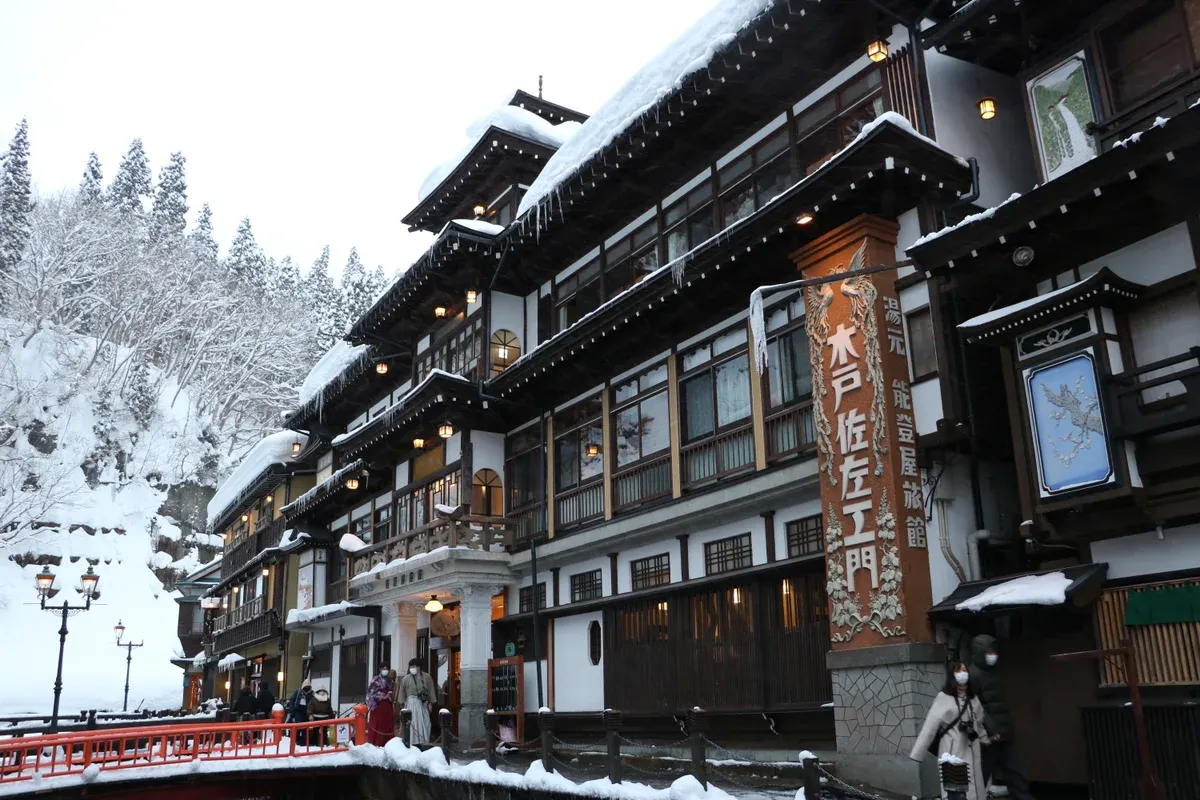 Multi-storey wooden Notoya ryokan under heavy snow