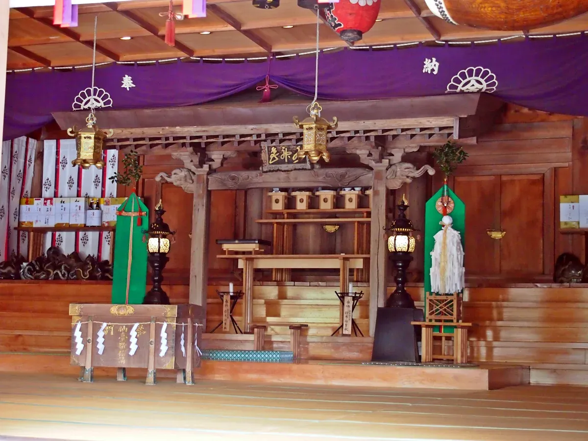 Interior of the Kanahebi Suijinja shrine hall with its purple banners and altar