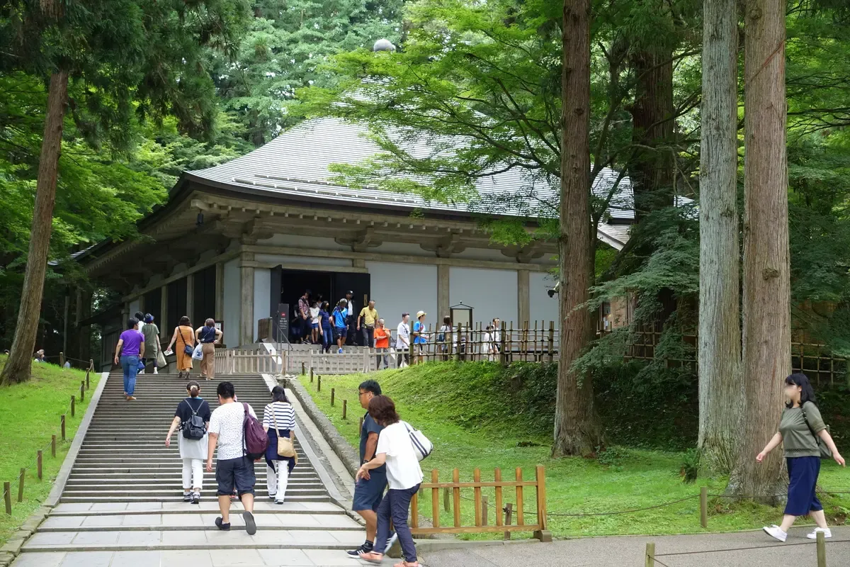 Stone steps leading up to the Konjikido cover hall among cedars