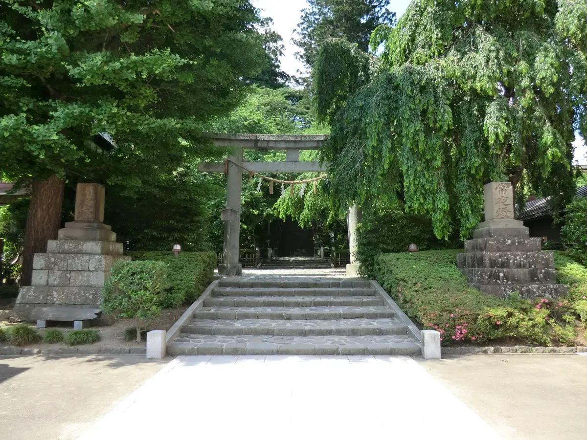 Stone torii and steps leading up to Osaki Hachimangu shrine among old trees in Sendai