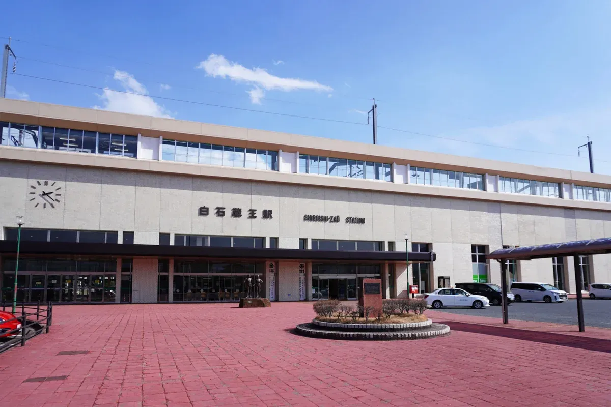 Shiroishi-Zao Station west exit building and brick plaza under a blue sky in Miyagi