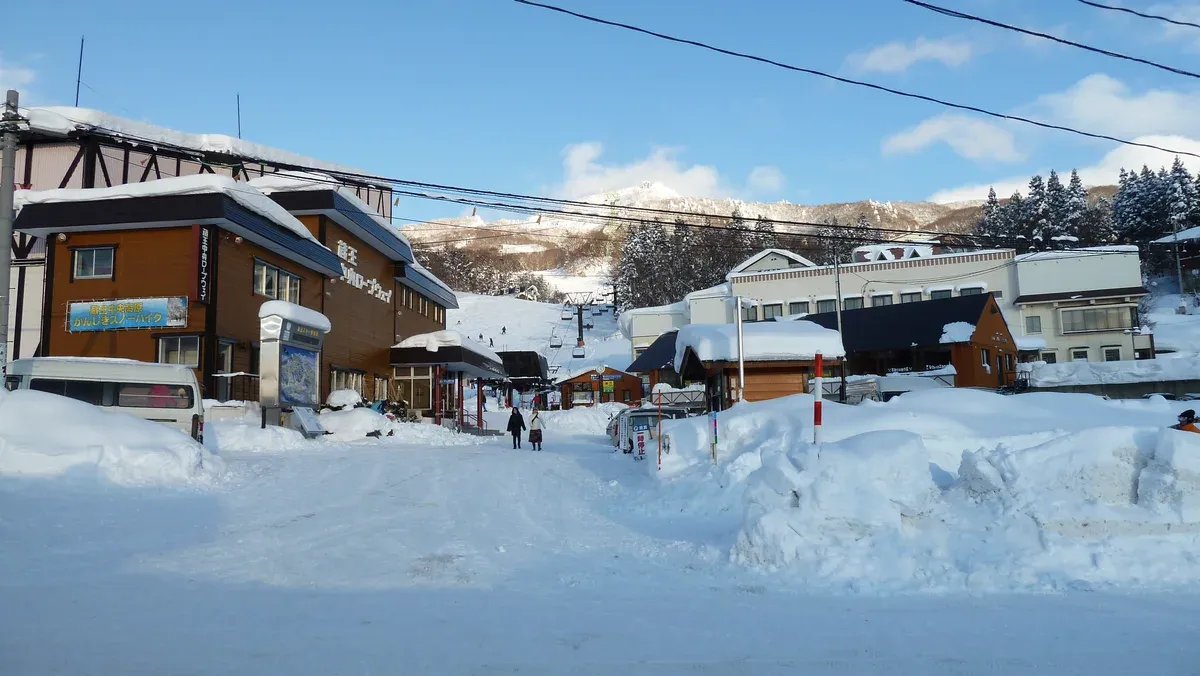 Snowbound Zao village street with lodges beneath a blue sky